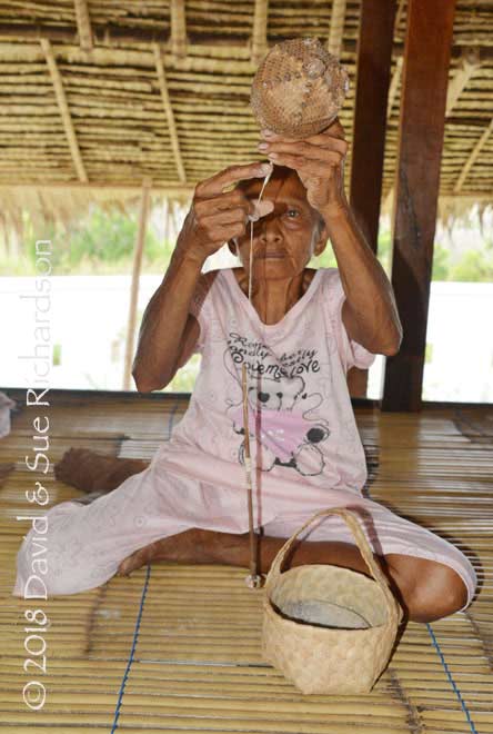 Description: An elderly woman drop spinning in Oirata Barat