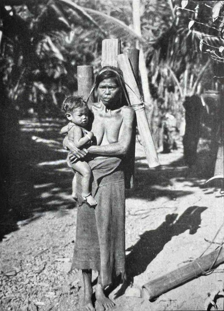 Description: A mother wearing a ragged plain woven tube skirt